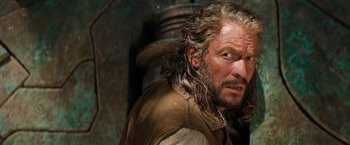 Movie still from “Tomb Raider” (2018), directed by Roar Uthaug – A person with long hair and a beard; Close Up shot, Over the shoulder angle