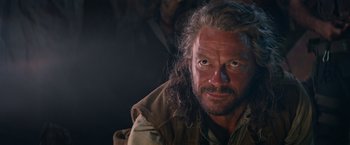 Movie still from “Tomb Raider” (2018), directed by Roar Uthaug – A person with long grey hair; Close Up shot, Over the shoulder angle