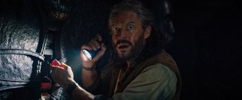 Movie still from “Tomb Raider” (2018), directed by Roar Uthaug – A man holding a cell phone up to his face; Close Up shot, Low angle