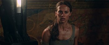 Movie still from “Tomb Raider” (2018), directed by Roar Uthaug – A person wearing a tank top; Close Up shot, Over the shoulder angle