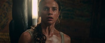 Movie still from “Tomb Raider” (2018), directed by Roar Uthaug – A person wearing a tank top; Close Up shot, Low angle