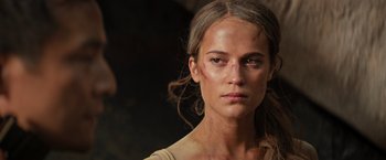 Movie still from “Tomb Raider” (2018), directed by Roar Uthaug – A person wearing a shirt; Close Up shot, Low angle