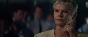 Movie still from “Tomorrow Never Dies” (1997), directed by Roger Spottiswoode – An older woman is looking into the distance; Close Up shot, Low angle