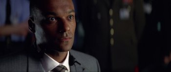 Movie still from “Tomorrow Never Dies” (1997), directed by Roger Spottiswoode – A person wearing a suit and tie; Close Up shot, Low angle