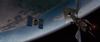 Movie still from “Tomorrow Never Dies” (1997), directed by Roger Spottiswoode – An image of a satellite in the sky above the earth; Extreme Wide shot, Overhead angle