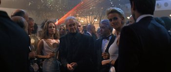 Movie still from “Tomorrow Never Dies” (1997), directed by Roger Spottiswoode – A group of men and women standing next to each other; Medium shot, Over the shoulder angle