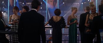 Movie still from “Tomorrow Never Dies” (1997), directed by Roger Spottiswoode – A group of people standing next to each other in front of a screen; Medium shot, Over the shoulder angle