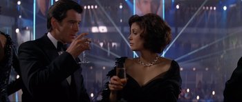 Movie still from “Tomorrow Never Dies” (1997), directed by Roger Spottiswoode – A man and a woman are drinking champagne; Medium shot, Over the shoulder angle
