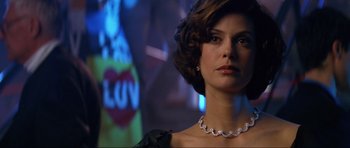 Movie still from “Tomorrow Never Dies” (1997), directed by Roger Spottiswoode – A person wearing a necklace; Close Up shot, Low angle