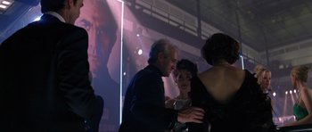 Movie still from “Tomorrow Never Dies” (1997), directed by Roger Spottiswoode – A group of people standing in front of a screen; Close Up shot, Over the shoulder angle