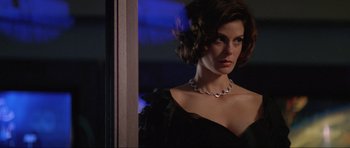 Movie still from “Tomorrow Never Dies” (1997), directed by Roger Spottiswoode – A woman in a black dress with a necklace; Close Up shot, Low angle