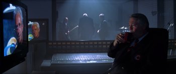 Movie still from “Tomorrow Never Dies” (1997), directed by Roger Spottiswoode – A man sitting in front of a computer keyboard; Medium shot, Over the shoulder angle