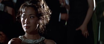 Movie still from “Tomorrow Never Dies” (1997), directed by Roger Spottiswoode – A person wearing a dress; Close Up shot, Over the shoulder angle