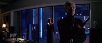 Movie still from “Tomorrow Never Dies” (1997), directed by Roger Spottiswoode – A man and a woman standing in front of a large window; Medium shot, Low angle
