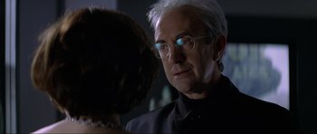 Movie still from “Tomorrow Never Dies” (1997), directed by Roger Spottiswoode – An older man wearing glasses looking at a young woman; Close Up shot, Over the shoulder angle