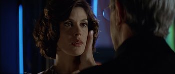 Movie still from “Tomorrow Never Dies” (1997), directed by Roger Spottiswoode – A woman looking in the mirror while holding her hand to her face; Close Up shot, Over the shoulder angle