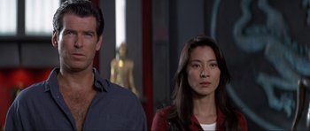 Movie still from “Tomorrow Never Dies” (1997), directed by Roger Spottiswoode – A man and a woman standing next to each other; Close Up shot, Low angle