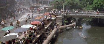 Movie still from “Tomorrow Never Dies” (1997), directed by Roger Spottiswoode – A group of people standing on top of a wooden dock; Extreme Wide shot, High angle