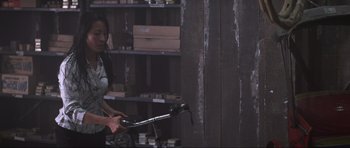 A woman is holding a bike in a room