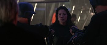 Movie still from “Tomorrow Never Dies” (1997), directed by Roger Spottiswoode – A woman in a black jacket and a man in a blue hat; Close Up shot, Over the shoulder angle