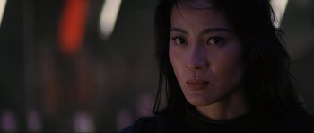 Movie still from “Tomorrow Never Dies” (1997), directed by Roger Spottiswoode – A woman's face in the dark; Close Up shot, Over the shoulder angle