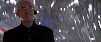 Movie still from “Tomorrow Never Dies” (1997), directed by Roger Spottiswoode – A man wearing headphones and a black jacket; Close Up shot, Low angle