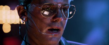 Movie still from “Top Gun” (1986), directed by Tony Scott – A person wearing glasses; Close Up shot, Low angle
