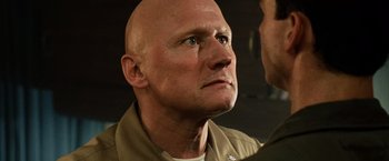 Movie still from “Top Gun” (1986), directed by Tony Scott – A man with a bald head looking into a mirror; Close Up shot, Low angle