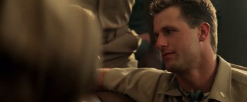 Movie still from “Top Gun” (1986), directed by Tony Scott – A person sitting on a couch; Close Up shot, Over the shoulder angle