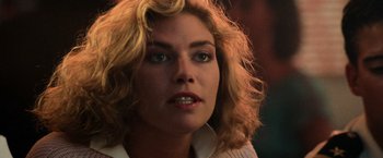 Movie still from “Top Gun” (1986), directed by Tony Scott – A person with blonde hair; Close Up shot, Over the shoulder angle