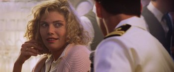Movie still from “Top Gun” (1986), directed by Tony Scott – A woman sitting next to a man in a uniform; Close Up shot, Over the shoulder angle