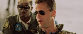 Movie still from “Top Gun” (1986), directed by Tony Scott – A person wearing sunglasses; Close Up shot, Low angle