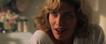 Movie still from “Top Gun” (1986), directed by Tony Scott – A woman with blonde hair and blue eyes; Close Up shot, Low angle