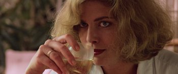 Movie still from “Top Gun” (1986), directed by Tony Scott – A person holding a glass of wine; Close Up shot, Low angle