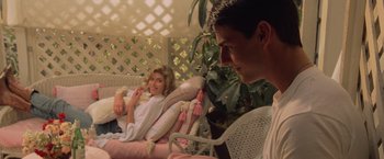 Movie still from “Top Gun” (1986), directed by Tony Scott – A man and a woman sitting on a couch; Medium shot, Over the shoulder angle