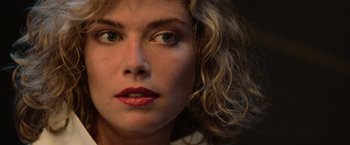 Movie still from “Top Gun” (1986), directed by Tony Scott – A person with curly blonde hair; Close Up shot, Low angle