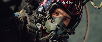 Movie still from “Top Gun” (1986), directed by Tony Scott – A person wearing a pilot's helmet; Close Up shot, Low angle