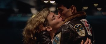 Movie still from “Top Gun” (1986), directed by Tony Scott – A man and a woman kissing each other; Close Up shot, Low angle
