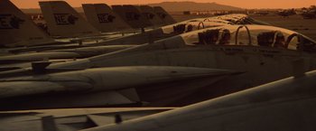 Movie still from “Top Gun” (1986), directed by Tony Scott – A bunch of fighter jets parked in a lot; Extreme Wide shot, High angle