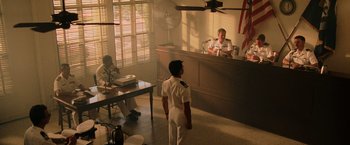 Movie still from “Top Gun” (1986), directed by Tony Scott – A man in a uniform in front of an officer; Wide shot, High angle