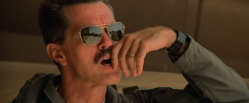 Movie still from “Top Gun” (1986), directed by Tony Scott – A person wearing sunglasses; Close Up shot, Low angle
