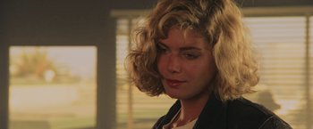 Movie still from “Top Gun” (1986), directed by Tony Scott – A person with curly hair; Close Up shot, Over the shoulder angle