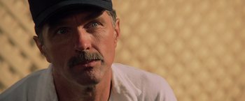 Movie still from “Top Gun” (1986), directed by Tony Scott – A man with a mustache wearing a hat; Close Up shot, Low angle