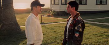 Movie still from “Top Gun” (1986), directed by Tony Scott – Two men standing next to each other on a field; Medium shot, Over the shoulder angle