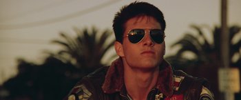 Movie still from “Top Gun” (1986), directed by Tony Scott – A person wearing sunglasses and a jacket; Close Up shot, Low angle