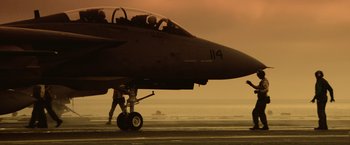 Movie still from “Top Gun” (1986), directed by Tony Scott – A fighter jet sitting on top of an airport runway; Extreme Wide shot, Low angle