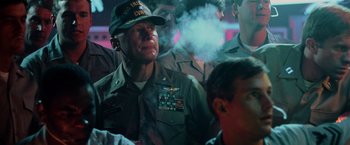 Movie still from “Top Gun” (1986), directed by Tony Scott – A man in a military uniform smoking a cigarette; Close Up shot, Over the shoulder angle