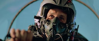 Movie still from “Top Gun” (1986), directed by Tony Scott – A person wearing a pilot's helmet; Close Up shot, Low angle