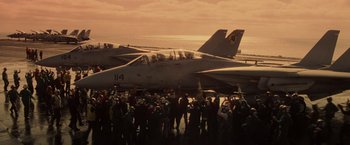Movie still from “Top Gun” (1986), directed by Tony Scott – A group of people standing next to two airplanes; Extreme Wide shot, High angle
