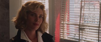 Movie still from “Top Gun” (1986), directed by Tony Scott – A person wearing a jacket near a window; Close Up shot, Over the shoulder angle